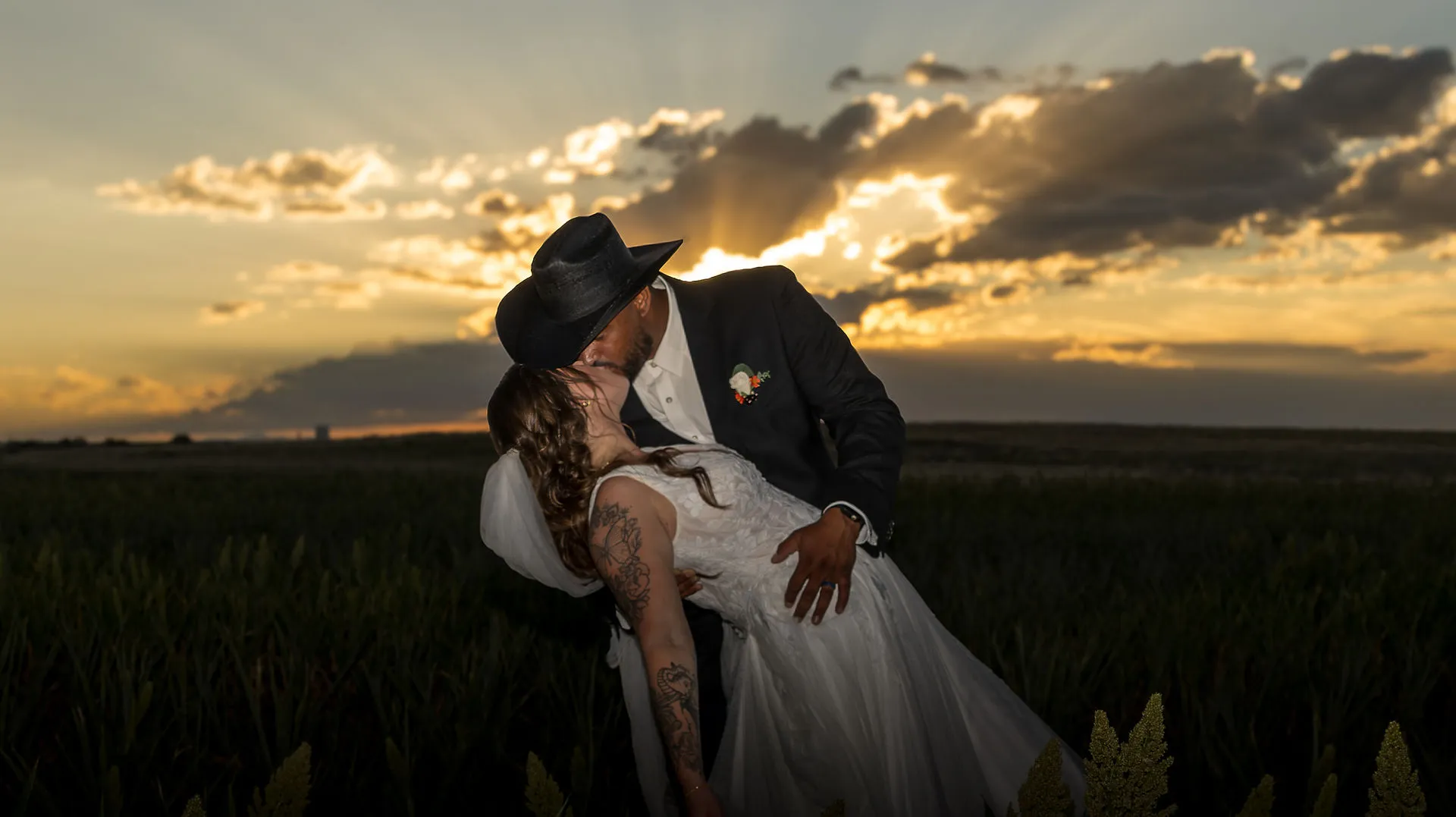 A couple kissing in a Colorado field at sunset